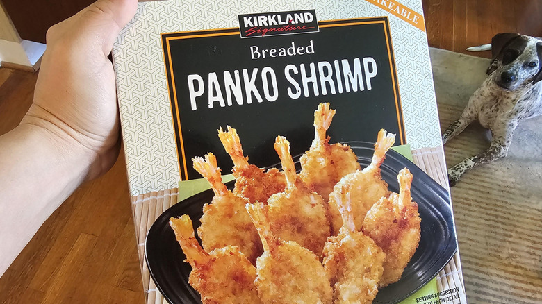 A hand holding a box of Kirkland Panko Shrimp