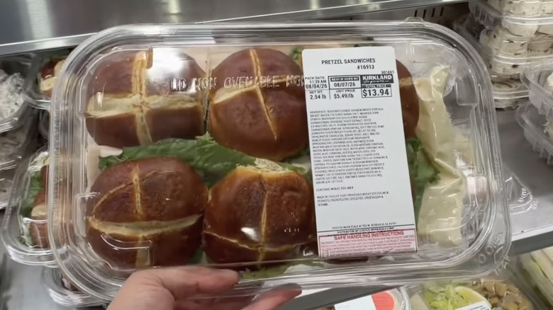 The ready-to-eat sliced chicken sandwiches on pretzel buns on display in the deli section of Costco