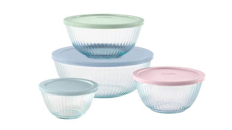 Four round Pyrex mixing bowls with pastel-colored lids from Costco on white background