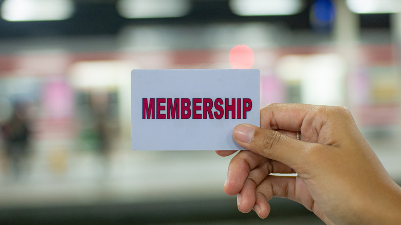 generic membership card held up between thumb and forefinger