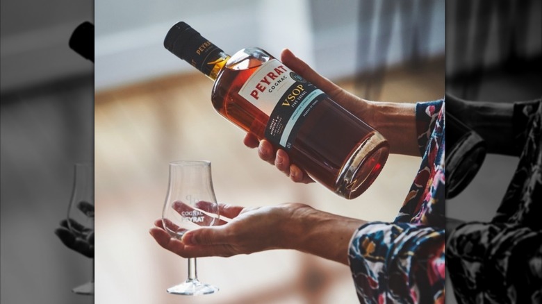 woman with peyrat cognac holding glass