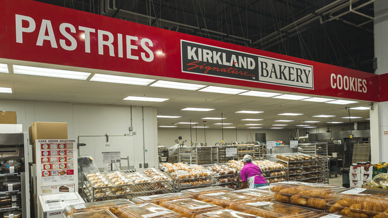An employee stacks new product on the shelves at Costco's bakery.