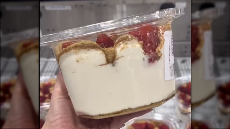 Person holding strawberries and cream dessert in Costco