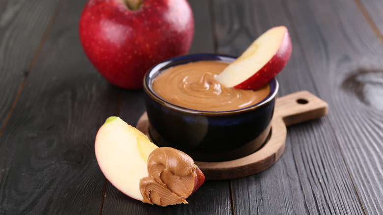 crock of peanut butter with apples dipping