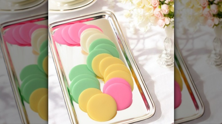 Lammes Candies Sherbet Mints on a silver-colored tray next to a vase of flowers