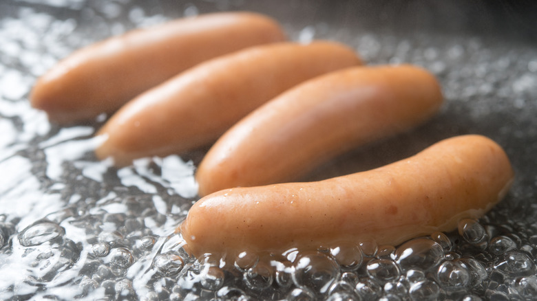 Hot dogs steaming in a thin layer of hot water