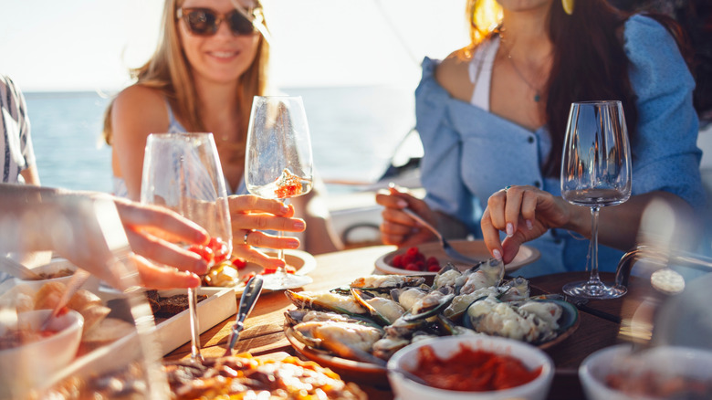 friends eating seafood together on a cruise together