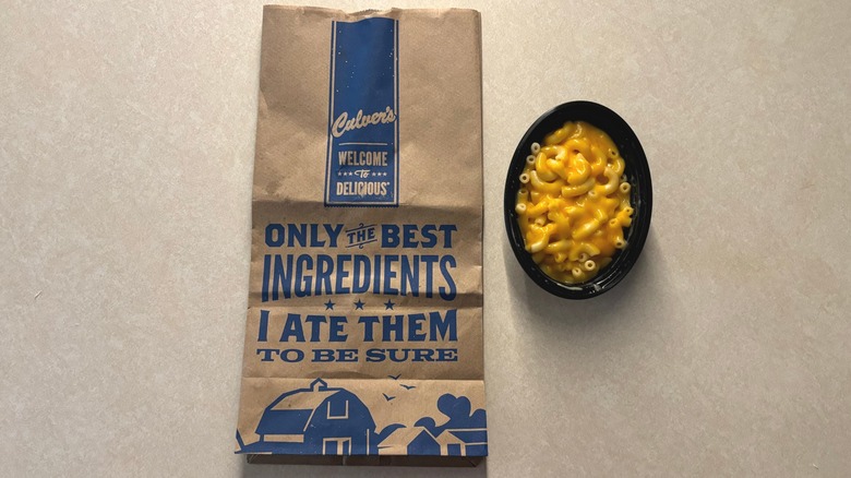 Culver's cheese and mac in a black dish next to a Culver's bag