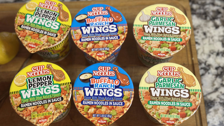 Nissin Cup Noodles wings flavors lined up on wooden board
