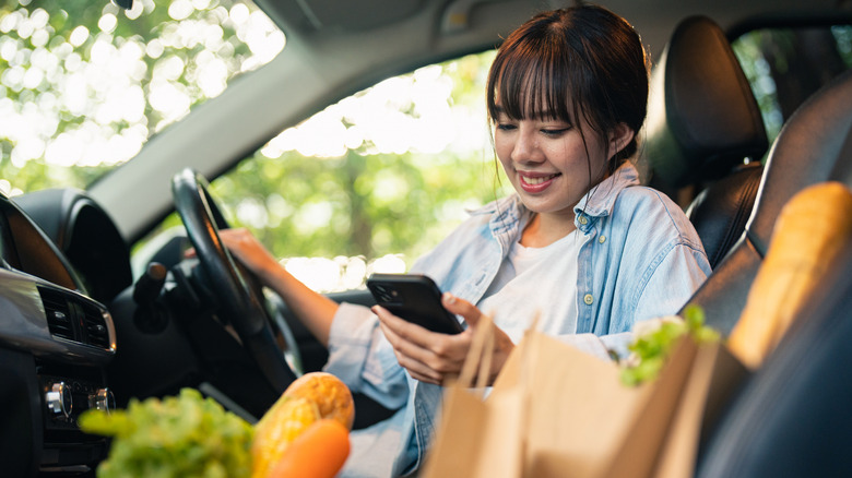 A woman picking up groceries curbside