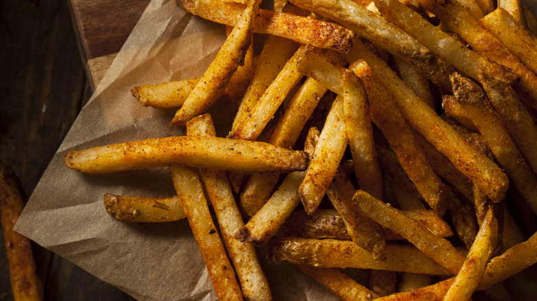 Top view of seasoned french fries on parchment paper