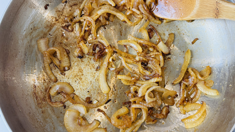 Caramelized onions in a saucepan with wooden spoon