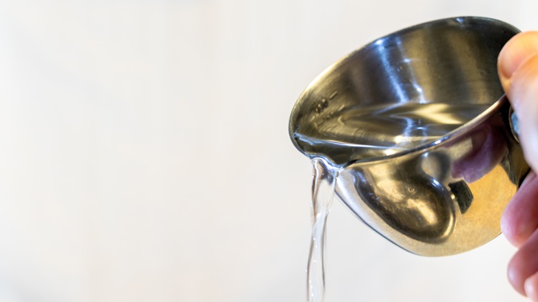 Pouring water from measuring cup