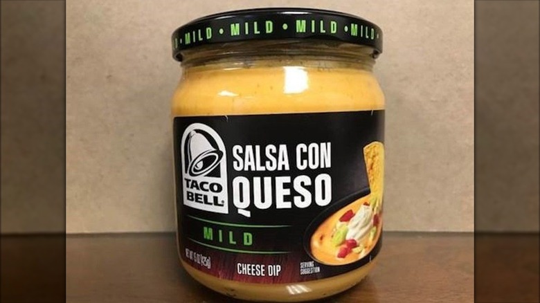 Jar of Taco Bell Salsa Con Queso Mild Cheese Dip on table