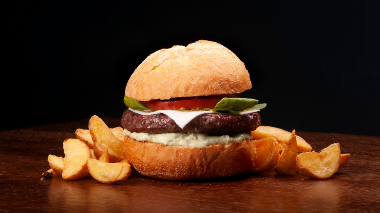 A Caprese Burger with potatoes around it