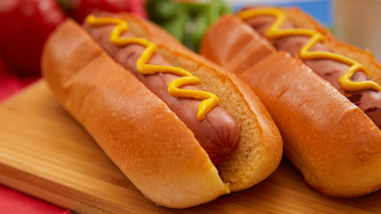 Two hot dogs with mustard