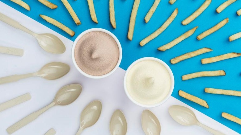 Vanilla and chocolate Frosty flavors surrounded by spoons and fries