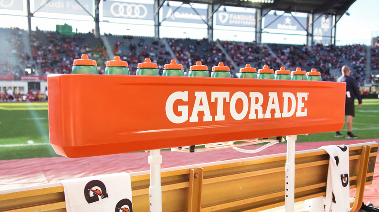 Stock photo of a bottles of Gatorade on the sidelines of a football game.