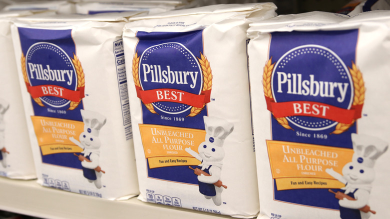 Three bags of Pillsbury all purpose flour on grocery store shelf