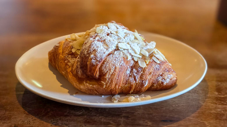 Almond croissant on plate on a wooden table