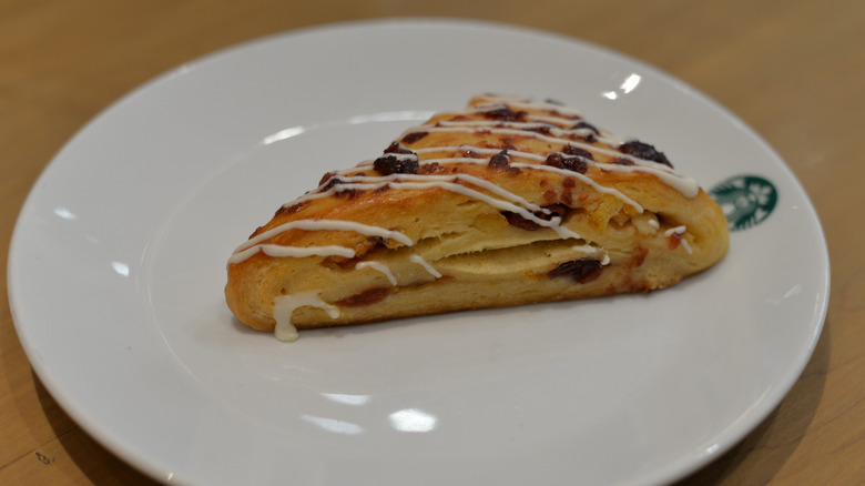 Cranberry orange scone on white plate with small Starbucks logo on it