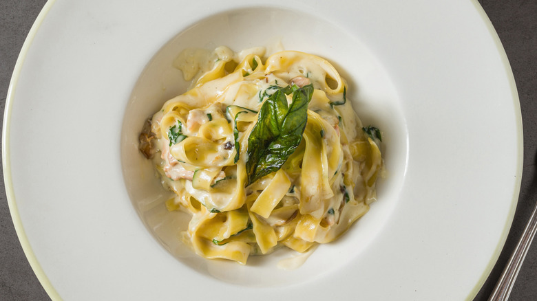 Top view of creamy fettuccine Alfredo pasta in white restaurant plate