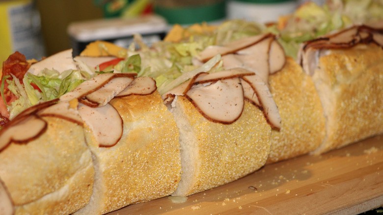 Pre-cut turkey sub served on wooden cutting board