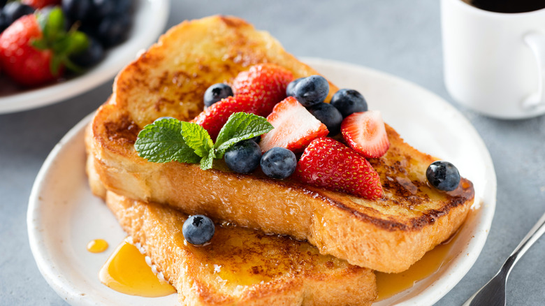Classic French toast topped with fresh berries and mint leaves
