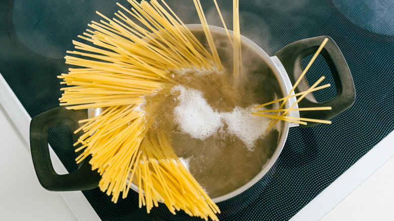Spaghetti being cooked in a pot of water