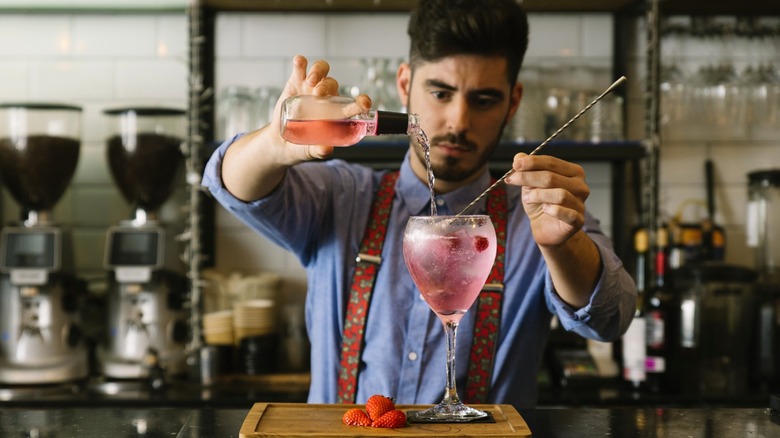 Bartender mixing drink behind bar