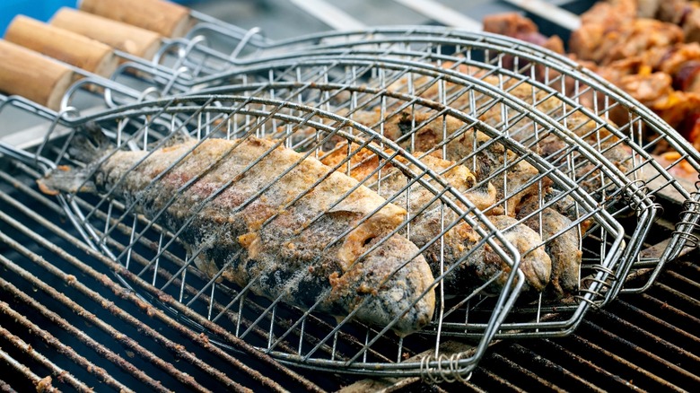Whole fish in grilling baskets on grill