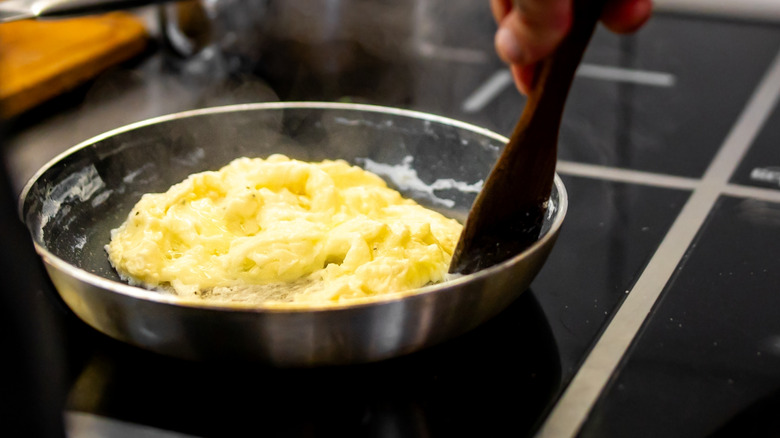 Stirring scrambled eggs in a frying pan