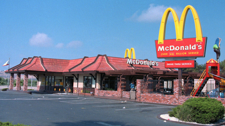 The exterior of a McDonald's in the 1980s with a playground out front.