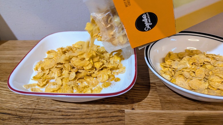 box pouring cereal into milk bowl