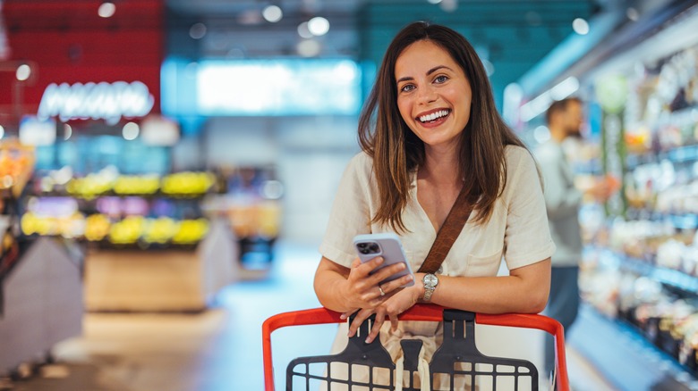 A happy young woman grocery shopping