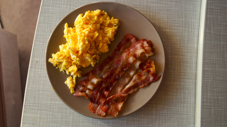 A plate of scrambled eggs and bacon