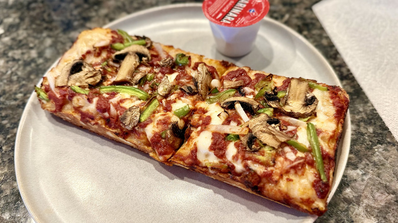 Veggie Domino pizza on a plate with a dip