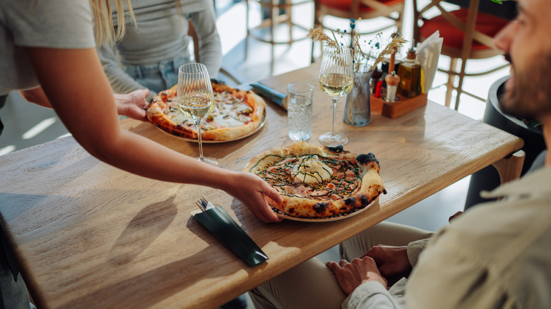 Serving pizza at restaurant