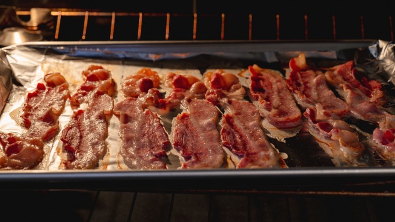 Bacon cooking on a sheet pan in an oven