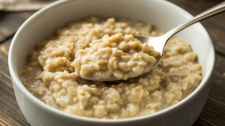 Spoon dipping into a bowl of cooked oatmeal