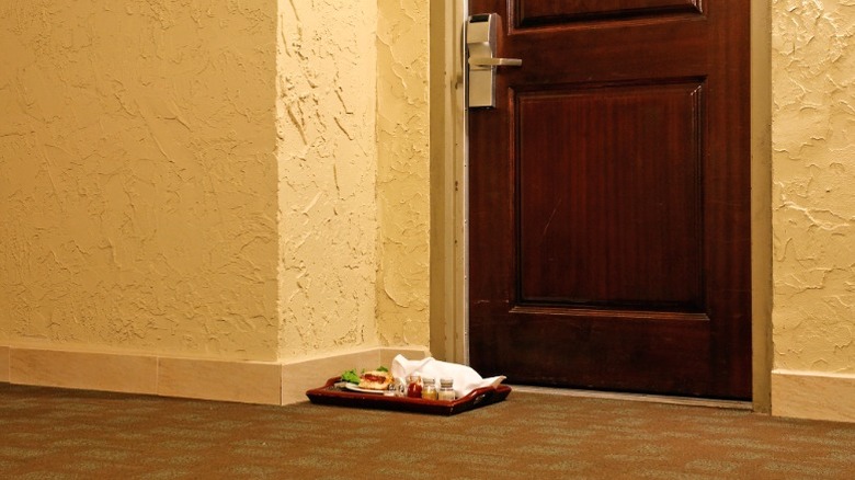 Dirty room service dishes in hallway outside hotel room