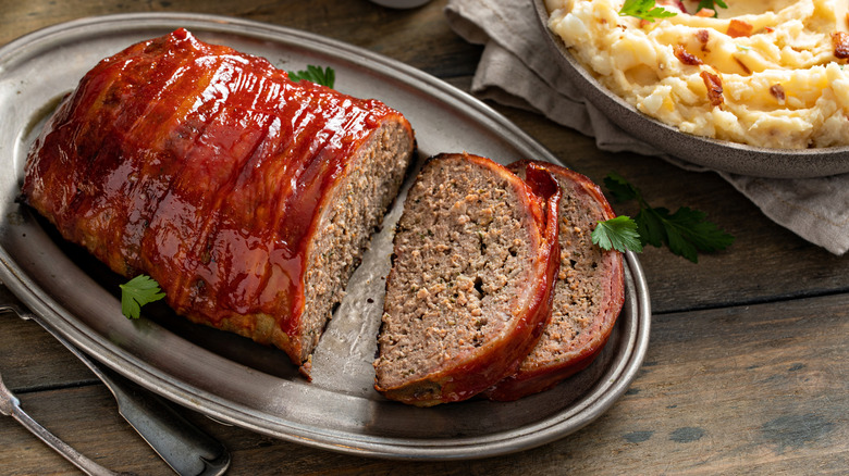 Top view of bacon-wrapped meatloaf on silver platter