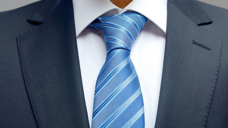 A close-up of a man wearing a suit and tie.