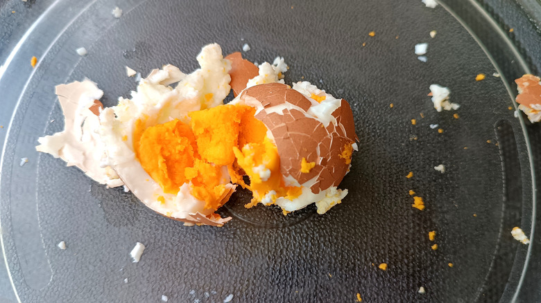 An exploded hard boiled egg on a glass microwave turntable