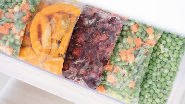 Bags of frozen vegetables in a freezer drawer