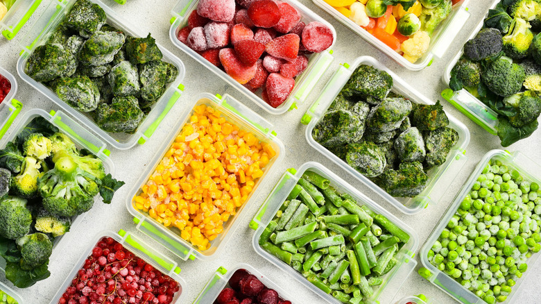Assorted open plastic containers of frozen fruits and vegetables