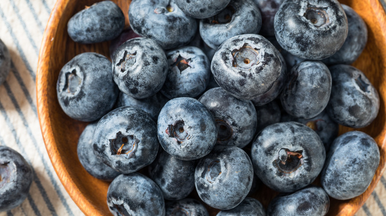 Wooden bowl full of blueberries.