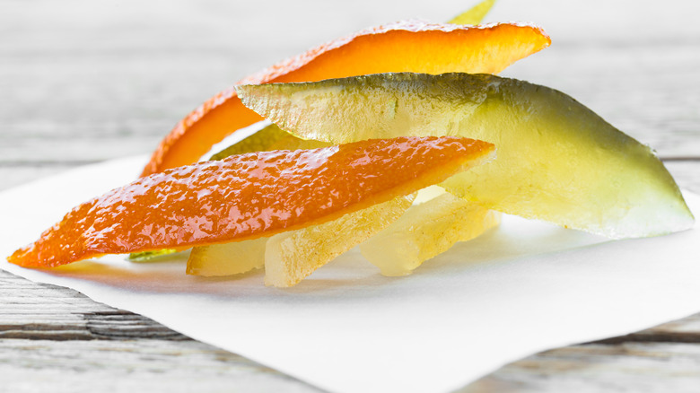 Strips of candied orange, lemon, and lime peel on a white plate