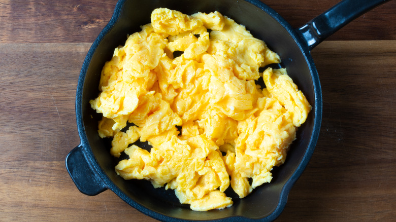 Fluffy scrambled eggs in a black pan