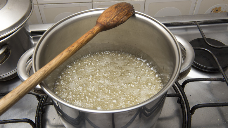 Boiling sugar and water in a saucepan on the stove